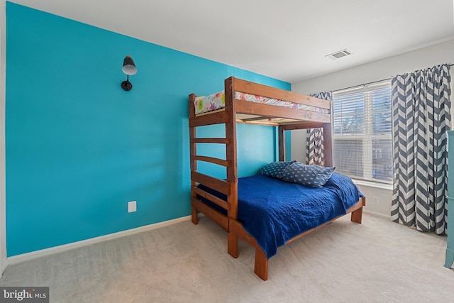 bedroom with visible vents, light carpet, and baseboards