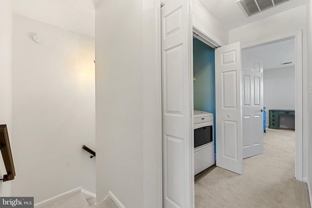 corridor with an upstairs landing, light carpet, visible vents, and baseboards