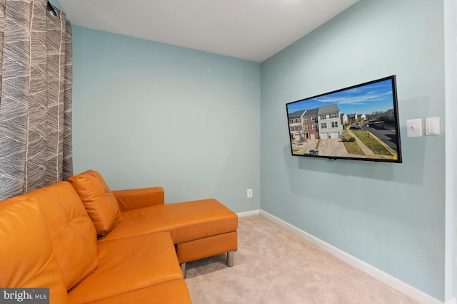 living area featuring light colored carpet and baseboards