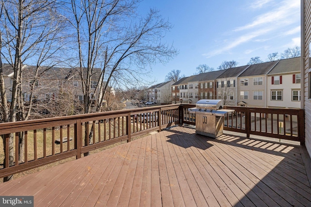 wooden terrace with a residential view and a grill