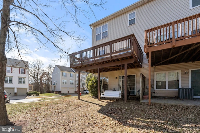 rear view of house with cooling unit and a wooden deck