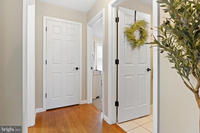 hallway with light wood finished floors and baseboards