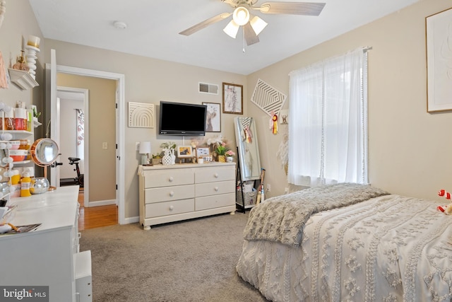 bedroom with light carpet, baseboards, visible vents, and a ceiling fan