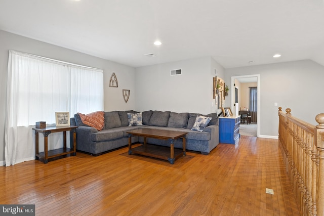 living room featuring light wood-style floors, baseboards, visible vents, and recessed lighting