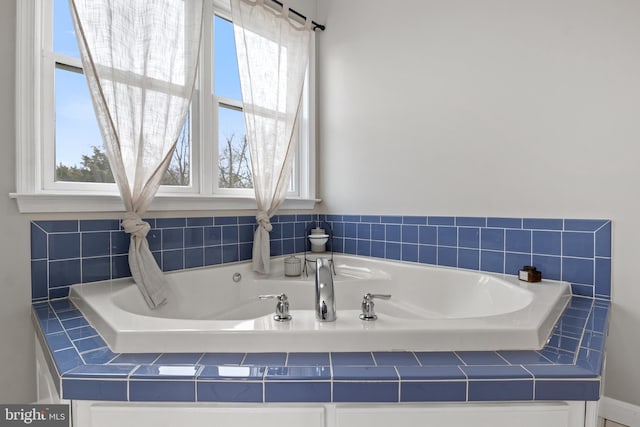 full bath with plenty of natural light and a bath