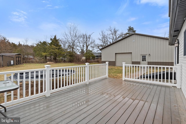 deck with a garage, a lawn, and an outdoor structure