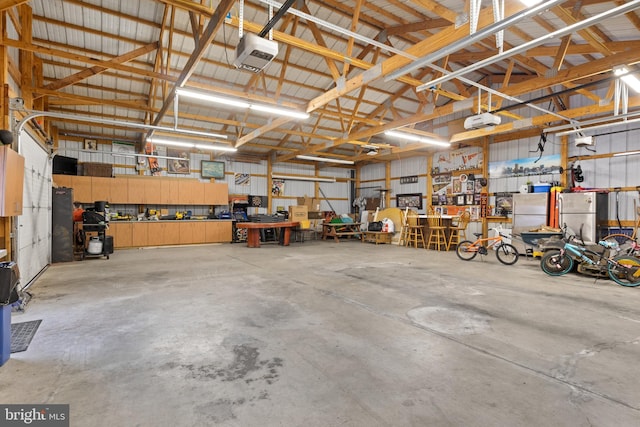 garage with a workshop area, metal wall, and a garage door opener