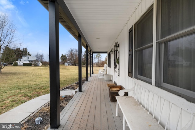 wooden terrace with a porch and a yard