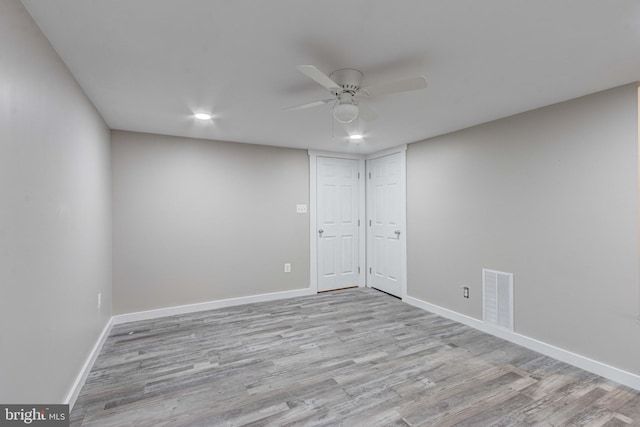 empty room with visible vents, baseboards, and wood finished floors