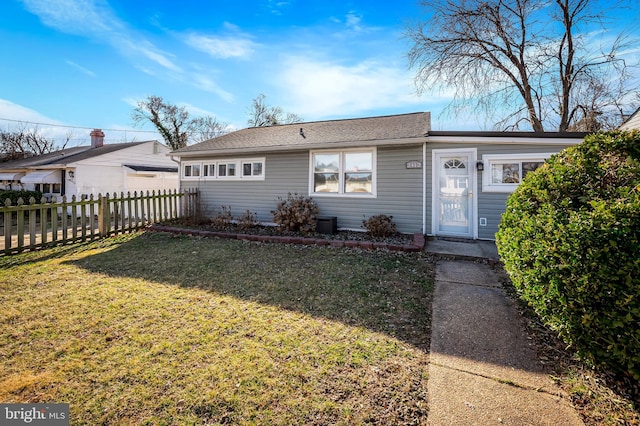 ranch-style home with a front yard and fence