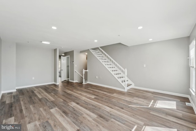 interior space with stairway, recessed lighting, wood finished floors, and baseboards