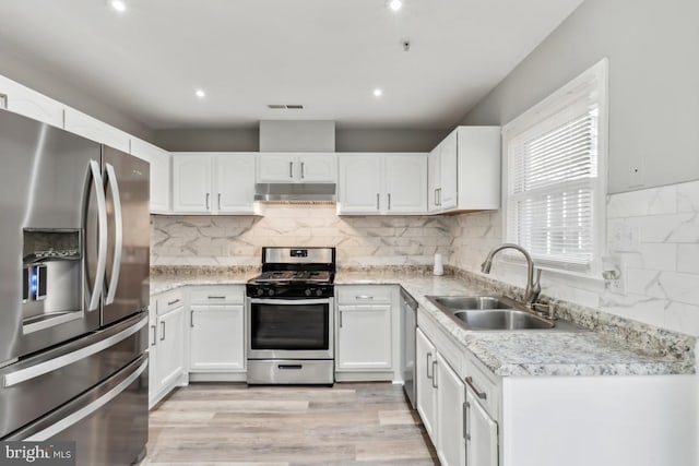 kitchen with visible vents, appliances with stainless steel finishes, under cabinet range hood, white cabinetry, and a sink