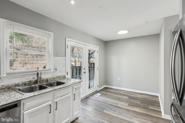 kitchen with appliances with stainless steel finishes, plenty of natural light, french doors, and a sink