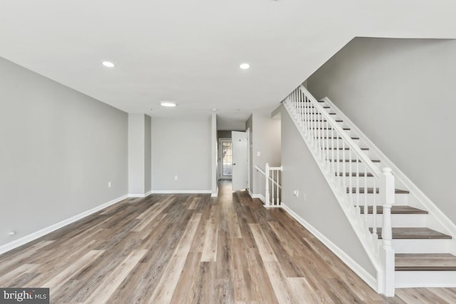 basement featuring recessed lighting, wood finished floors, and baseboards