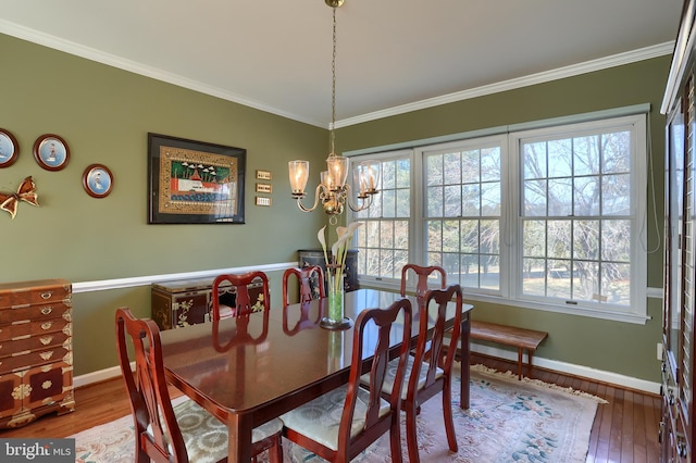 dining area featuring ornamental molding, wood finished floors, and baseboards