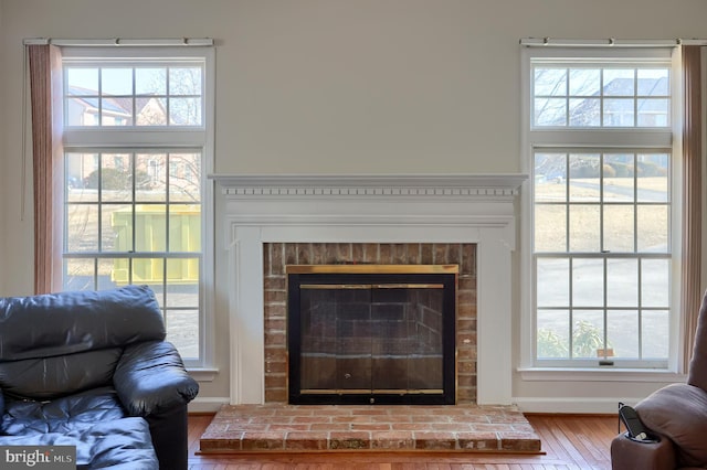 room details with a brick fireplace, baseboards, and wood finished floors