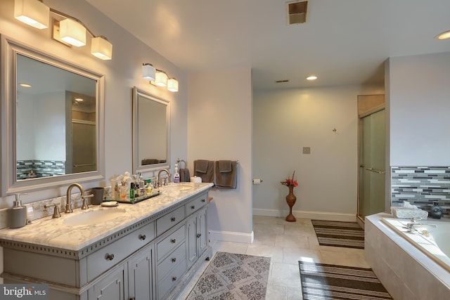 bathroom featuring double vanity, baseboards, a sink, and a shower with shower door