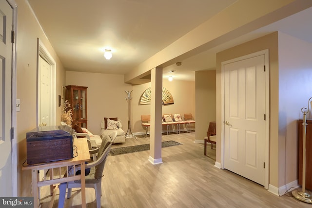 exercise area featuring light wood-style flooring and baseboards