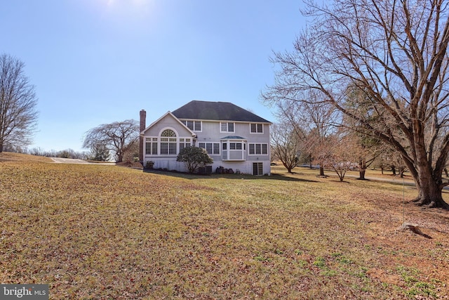 exterior space with a chimney and a lawn