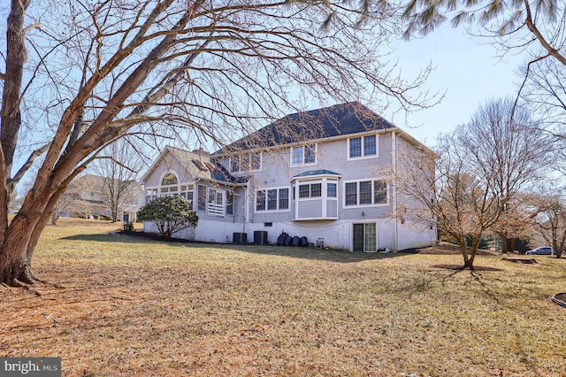 back of property featuring central AC unit and a lawn