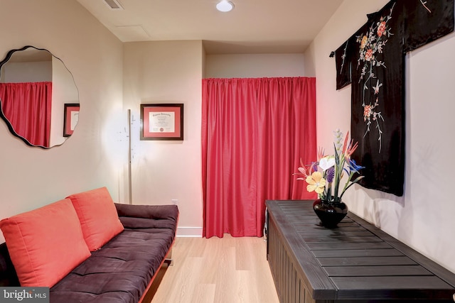 living area featuring light wood-style flooring and visible vents