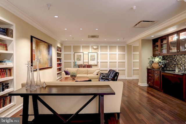 living area with visible vents, dark wood finished floors, crown molding, built in shelves, and recessed lighting