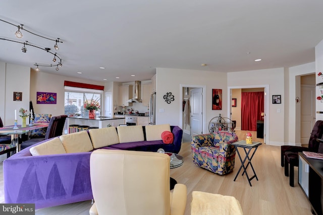 living room with light wood-type flooring, rail lighting, and recessed lighting