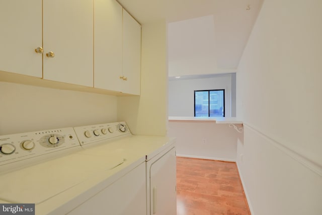 laundry area with washer and dryer, baseboards, cabinet space, and light wood finished floors