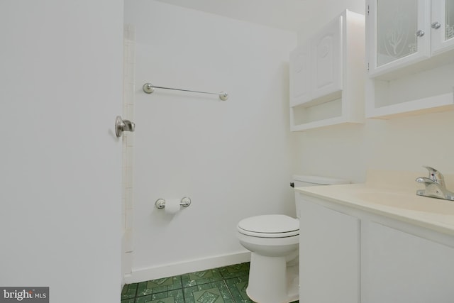 full bath with vanity, toilet, and baseboards