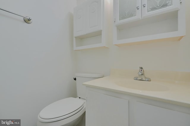 half bathroom with vanity and toilet