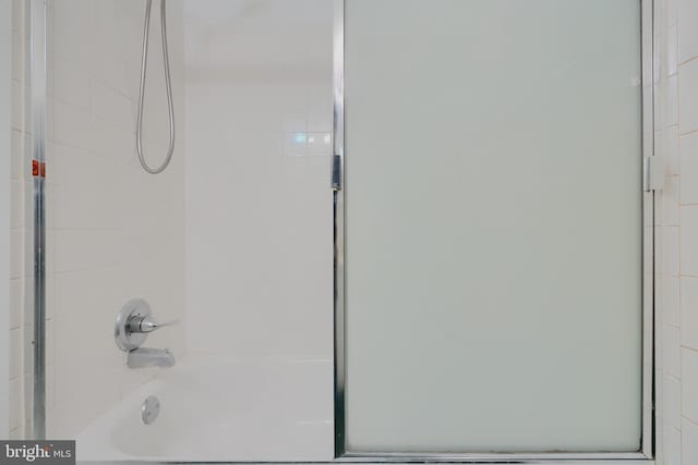 bathroom with combined bath / shower with glass door