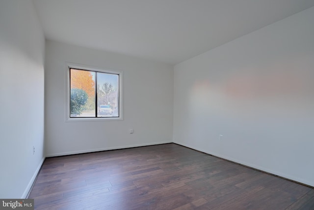 unfurnished room featuring dark wood-style floors and baseboards