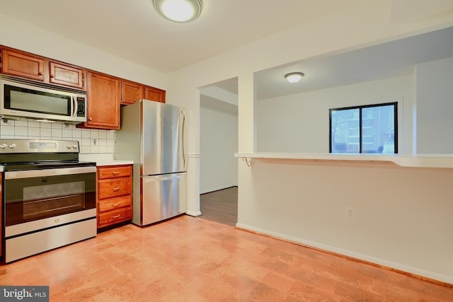 kitchen featuring tasteful backsplash, baseboards, brown cabinetry, appliances with stainless steel finishes, and light countertops