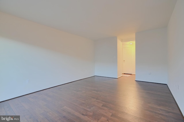 unfurnished room with dark wood finished floors