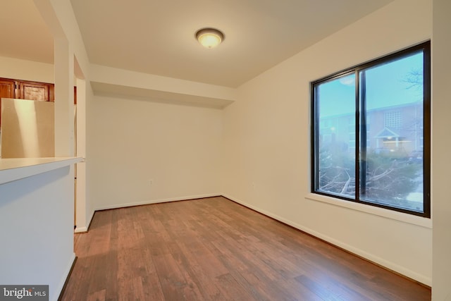 empty room featuring baseboards and wood finished floors