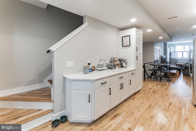 bar with recessed lighting, visible vents, baseboards, stairway, and light wood-type flooring