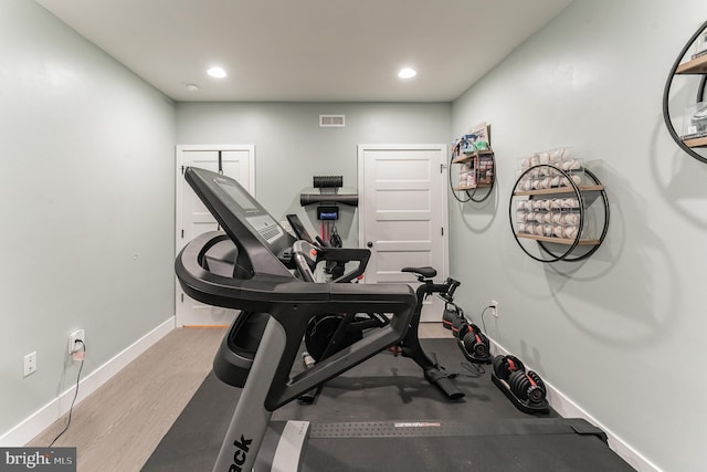 exercise area with light wood-type flooring, visible vents, baseboards, and recessed lighting