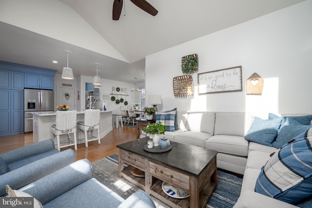 living area featuring high vaulted ceiling, ceiling fan, and wood finished floors