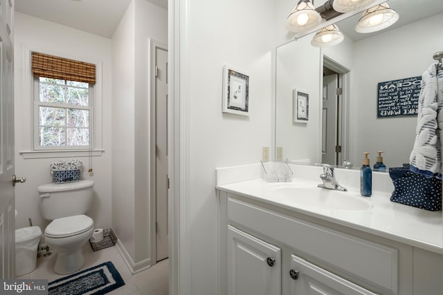 half bathroom featuring toilet, tile patterned floors, and vanity