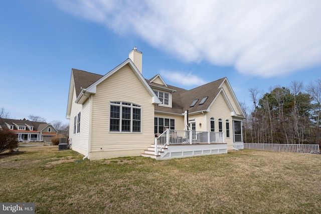 rear view of house featuring cooling unit, fence, a yard, a wooden deck, and a chimney