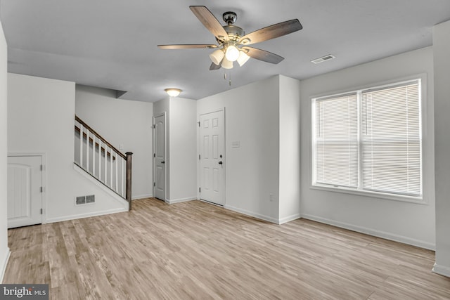 foyer entrance featuring visible vents, light wood finished floors, a ceiling fan, and stairway