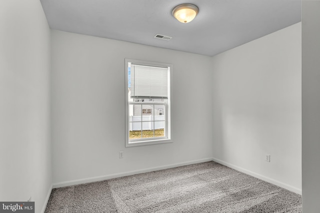 carpeted spare room featuring visible vents and baseboards