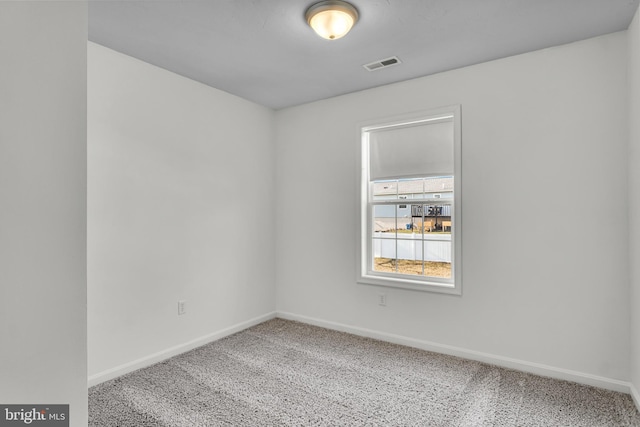 spare room featuring visible vents, carpet floors, and baseboards