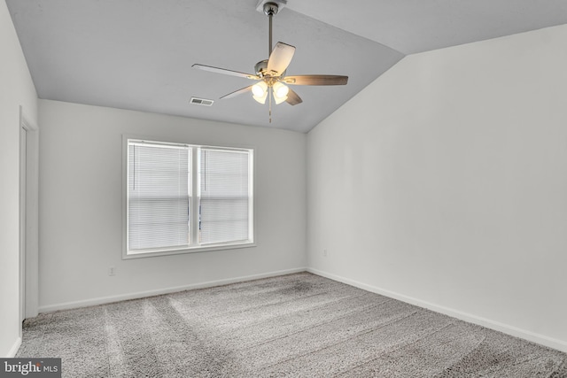 carpeted spare room featuring visible vents, lofted ceiling, baseboards, and ceiling fan