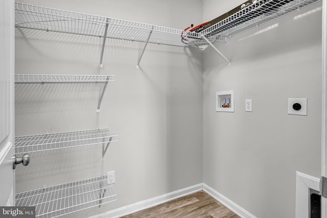 laundry room featuring baseboards, laundry area, hookup for a washing machine, wood finished floors, and electric dryer hookup