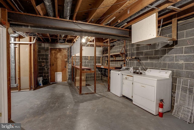 unfinished basement with concrete block wall and washing machine and dryer