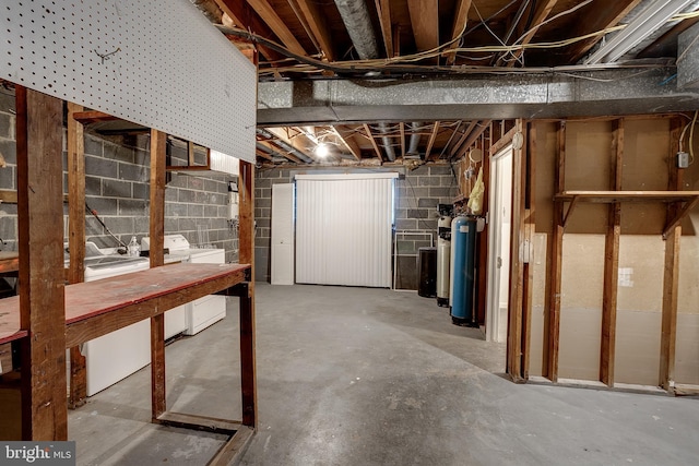 unfinished basement with washer and dryer and concrete block wall