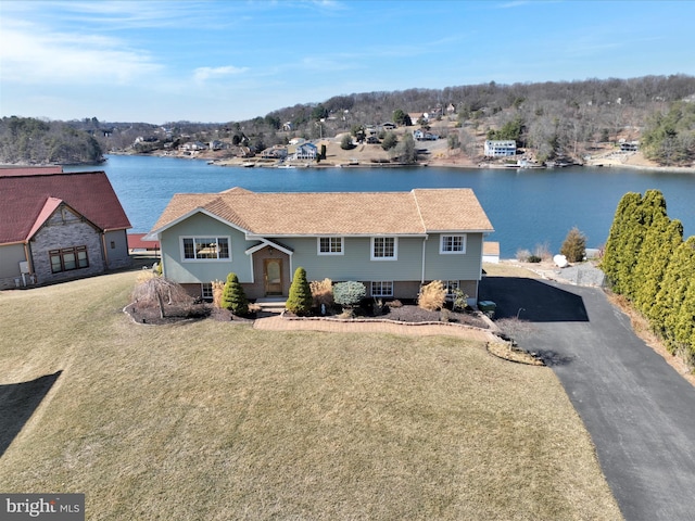 view of front of property featuring driveway, a front yard, and a water view