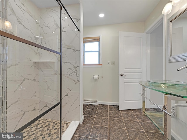 full bathroom with a marble finish shower, visible vents, baseboards, and a sink