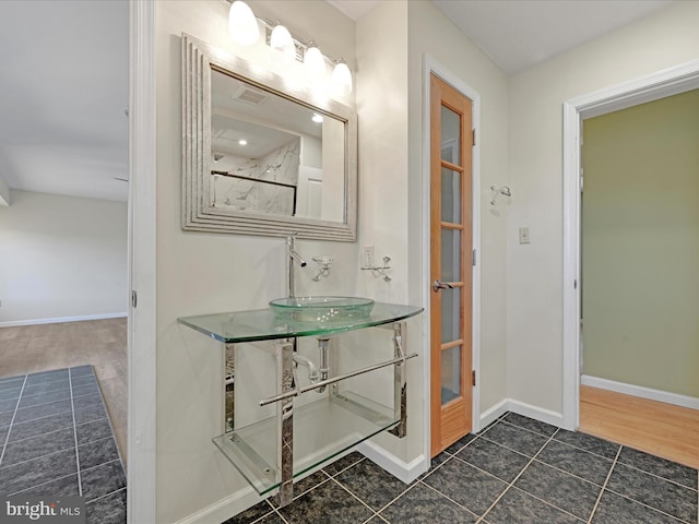 bathroom with tile patterned floors, baseboards, and a sink